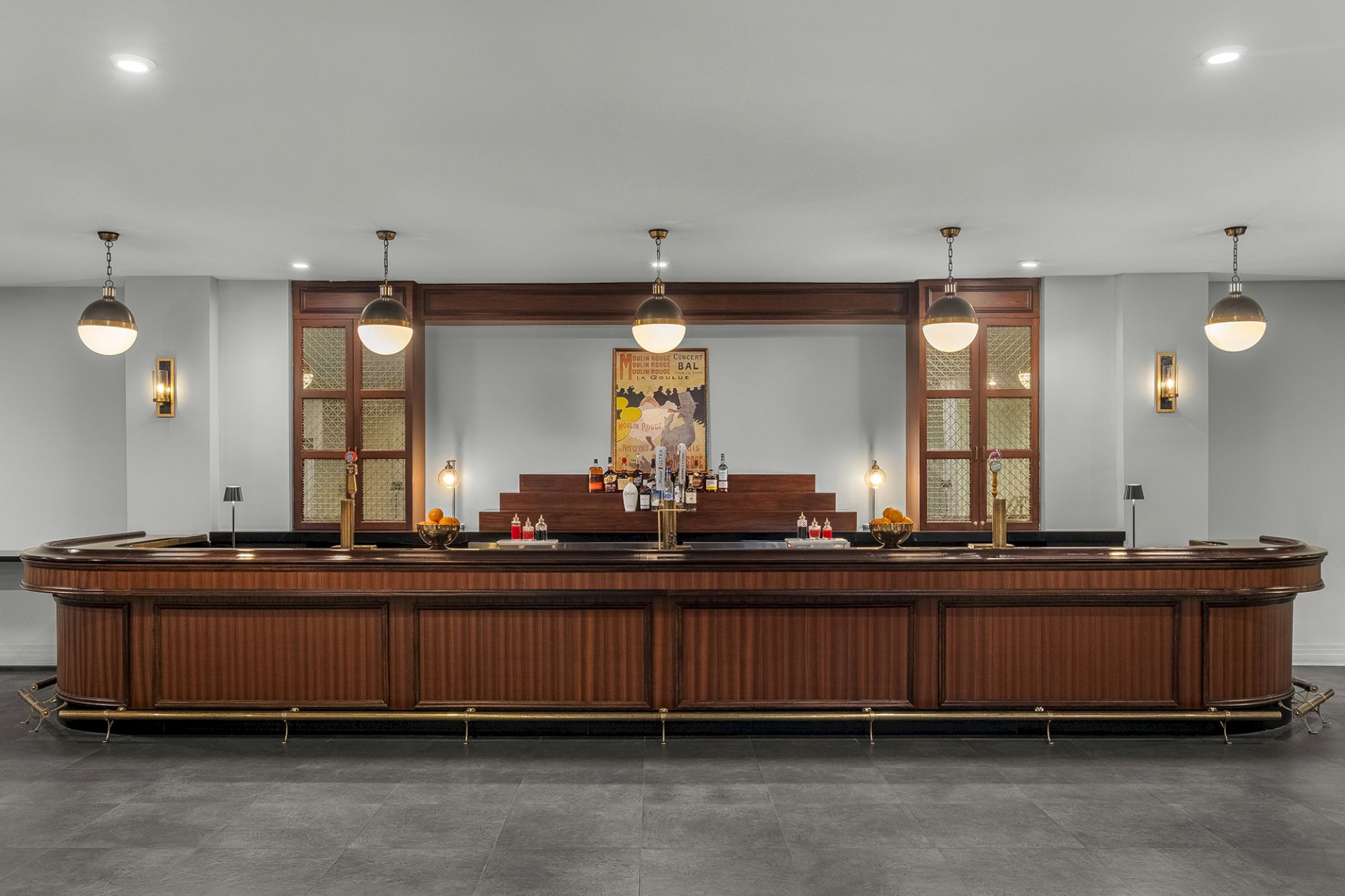 The image shows a sleek, modern bar with wooden paneling, pendant lights, and a central painting behind the counter.